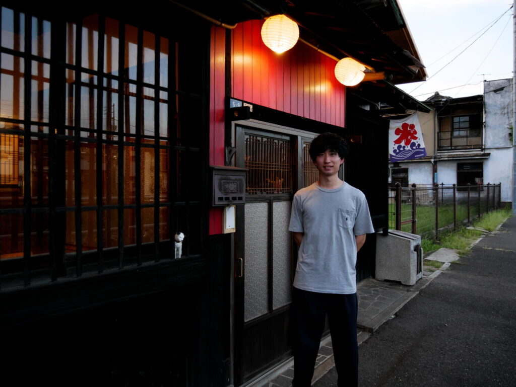 古民家カフェの前で笑顔で立つ男性