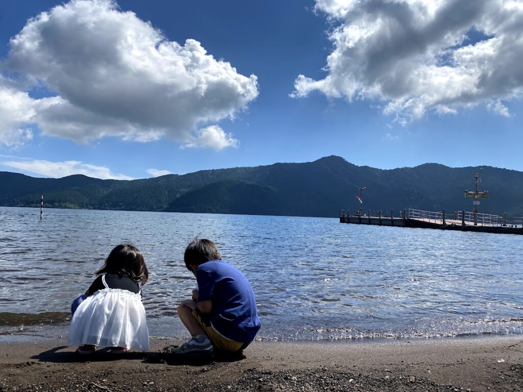 芦ノ湖湖畔でしゃがみこむ2人の子ども