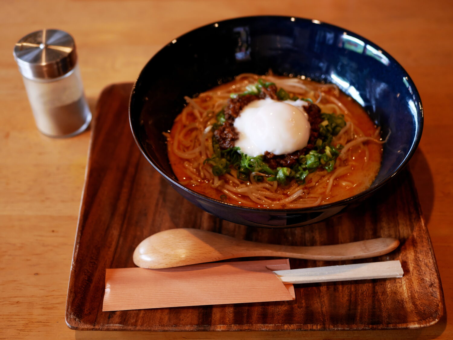 トレーに乗った担々麺と別添えの山椒ボトル