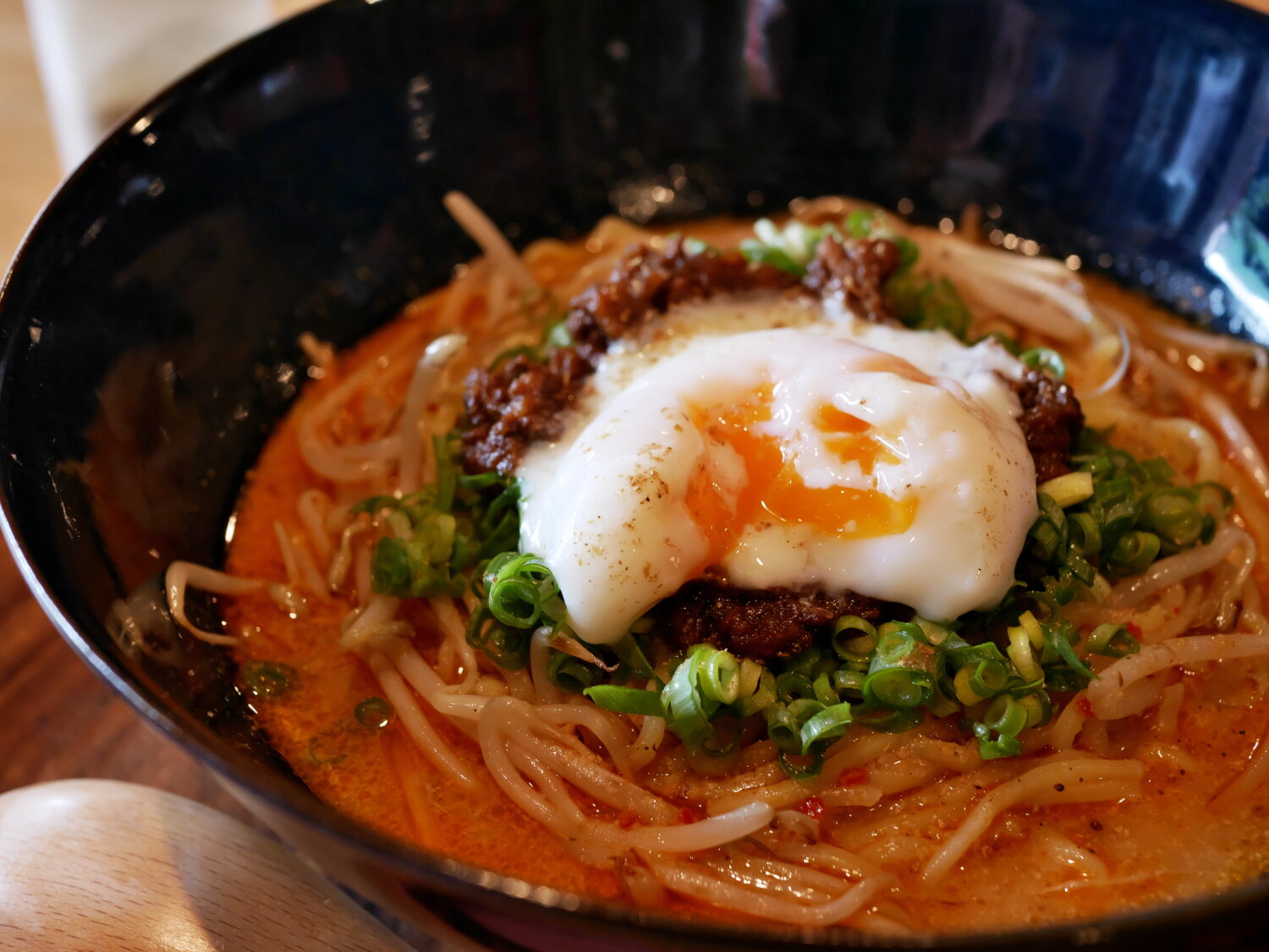 トッピングの温泉卵を崩した担々麺