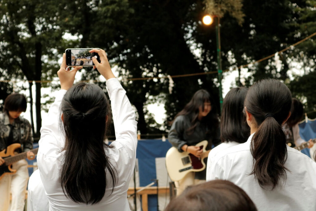 河内おいしいもん市2024－GOOD SOUND NIGHT：スマホでアーティストの写真を撮る高校生