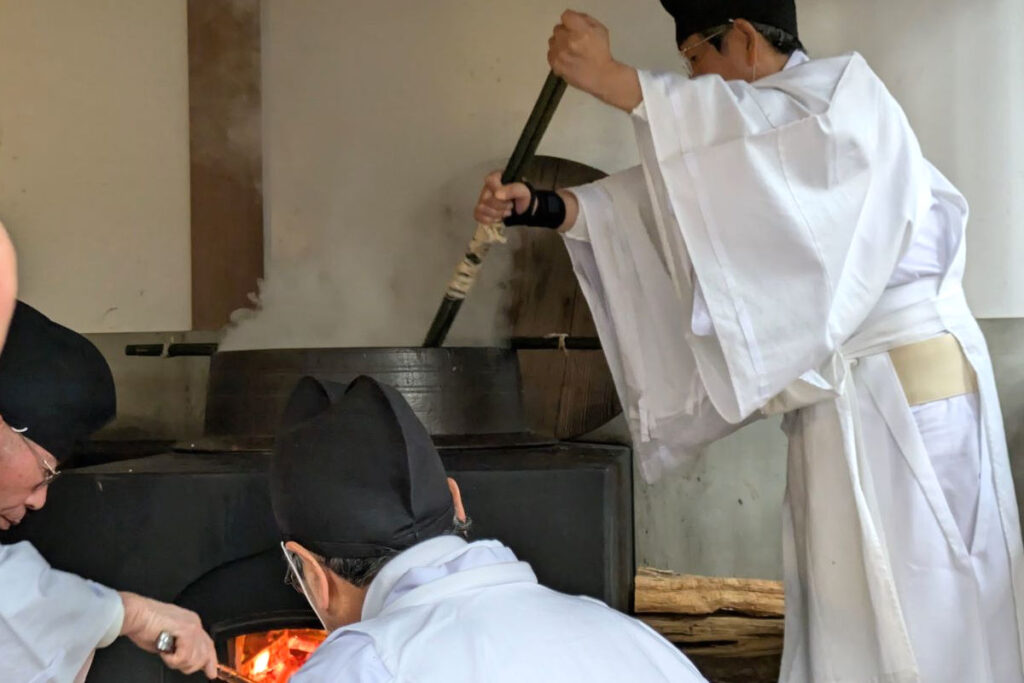 粥占神事（枚岡神社）｜小豆粥をかき混ぜる男性