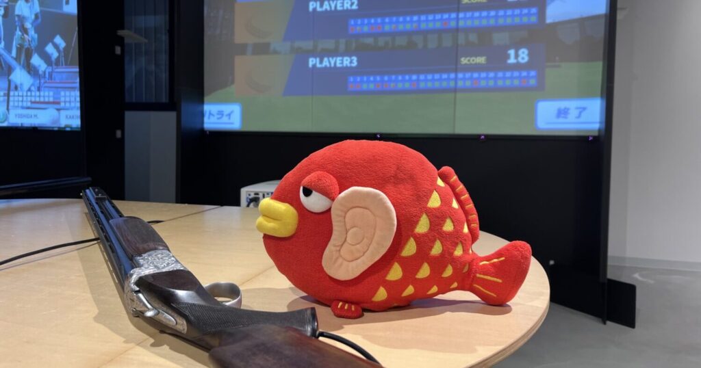 スクリーンの前の机にある、どうだい君と銃