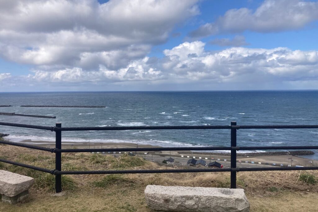 手前に柵があり、奥の方に空と海が見えます。