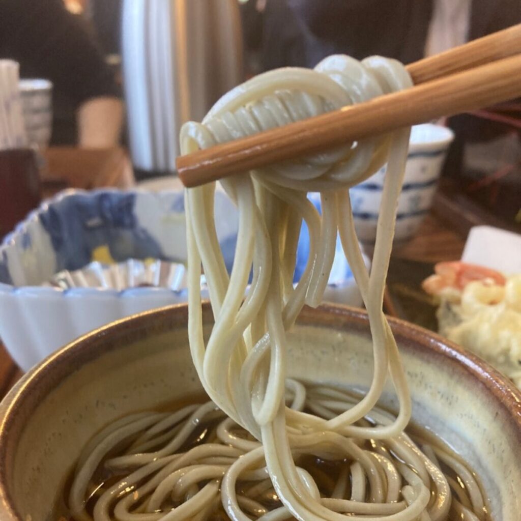 つゆにつけたへぎそばを箸で持ち上げています。