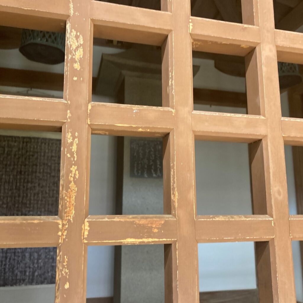 格子状の仕切りの奥に石塔があります。