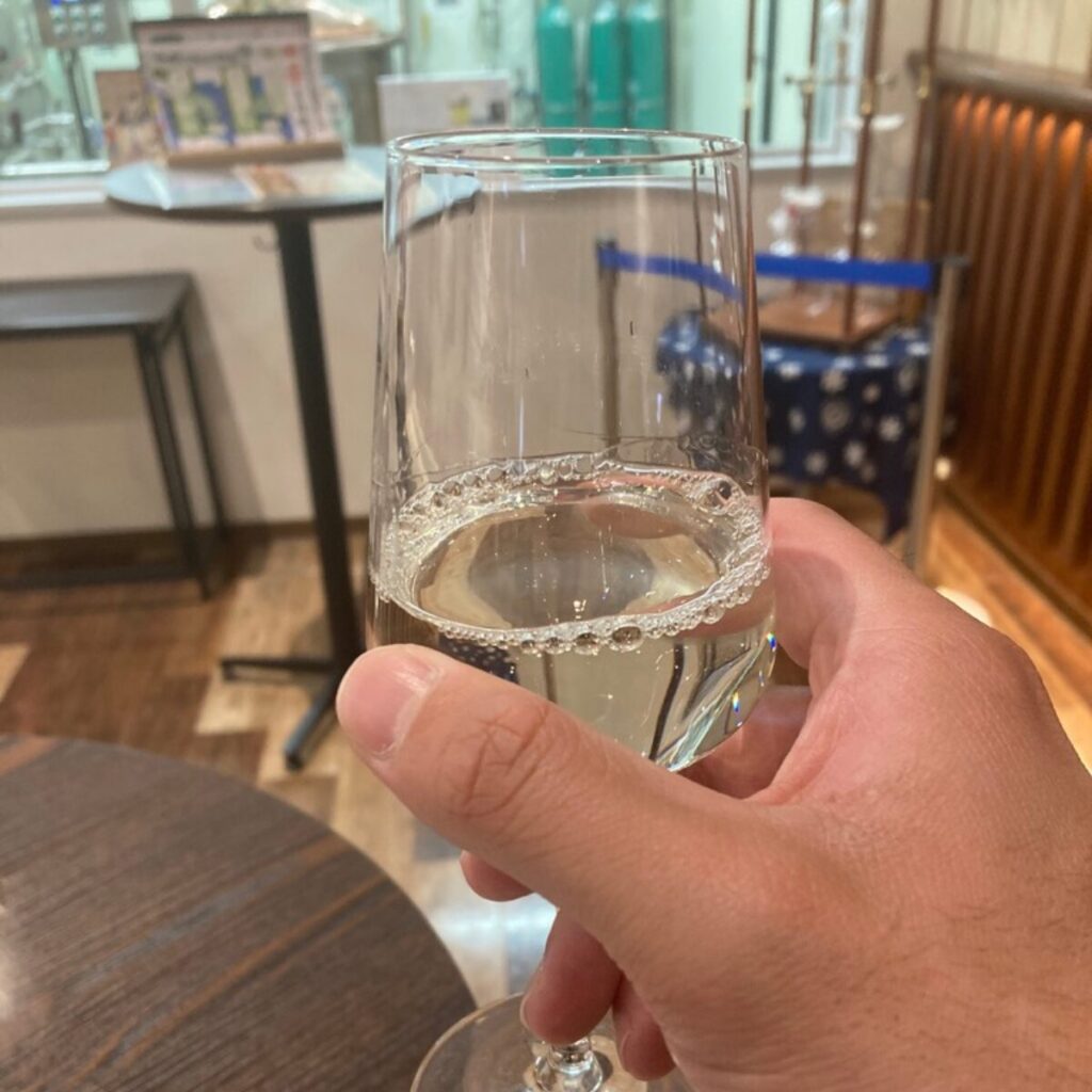 半透明の液体が入ったグラスを持っています。