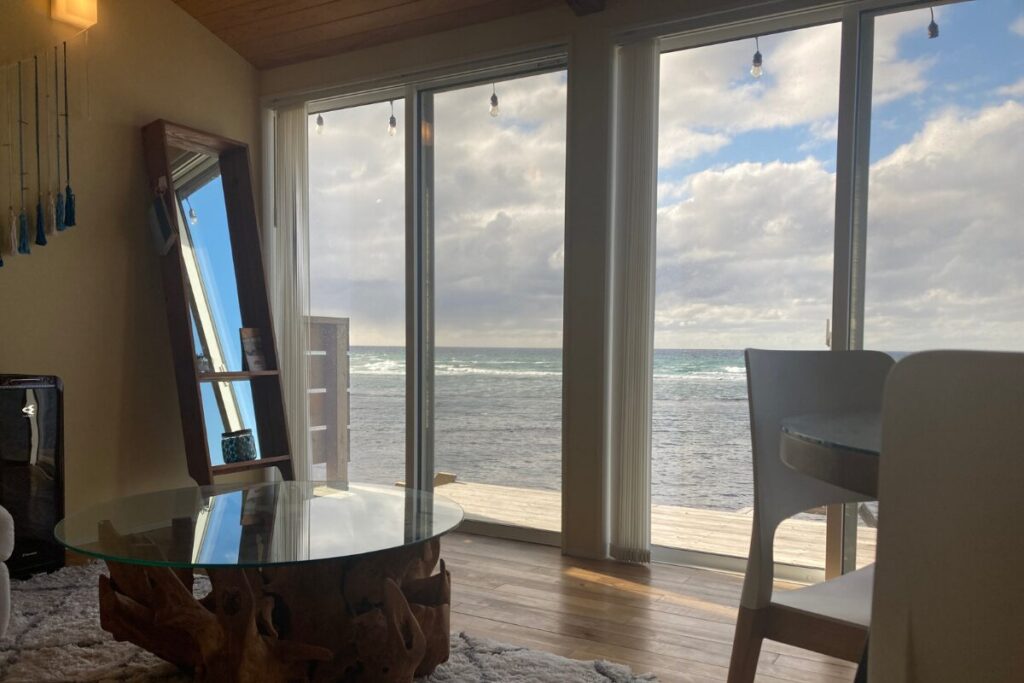 屋外の木製ベンチとテーブルです。左側には海が広がっています。