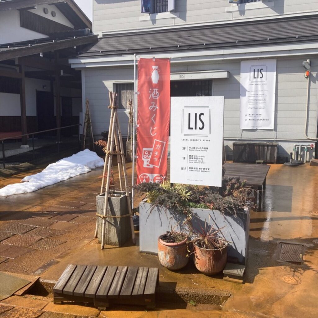「酒みくじガチャ」と書かれたのぼりと「LIS」という建物の看板が写っています。
