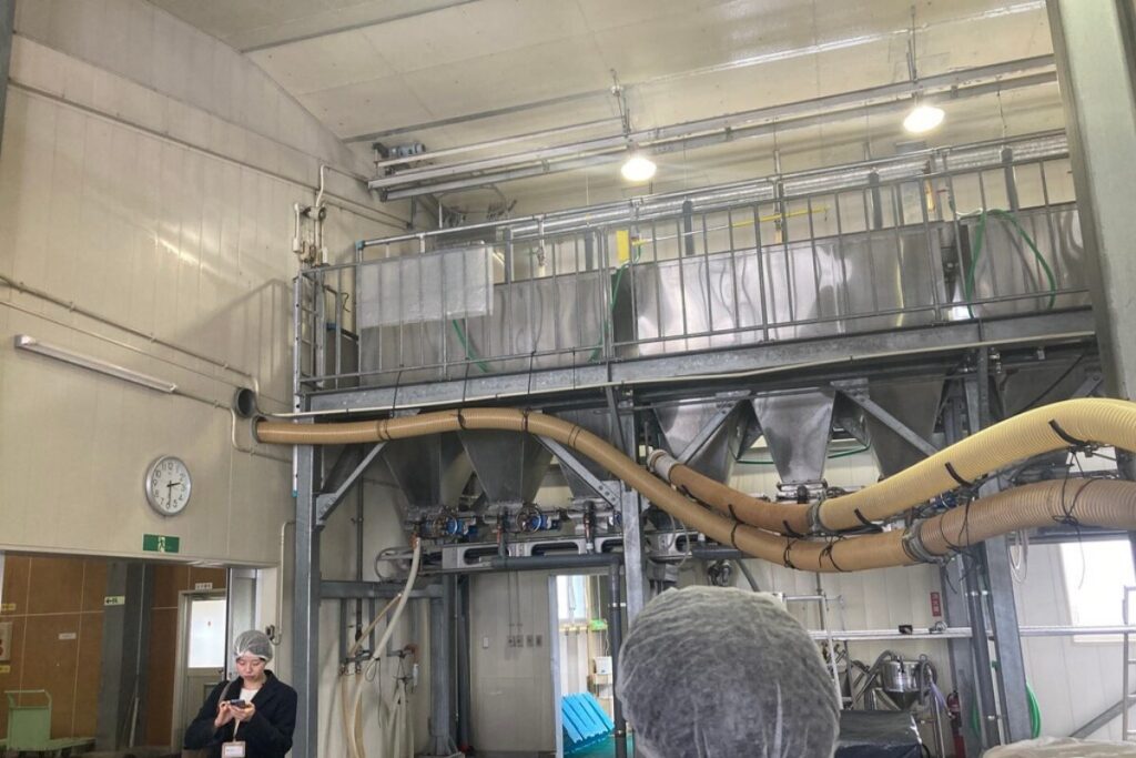 工場内が写っています。ギャラリーのようなスペースがあり、その下に白い円形のホースが付属しています。