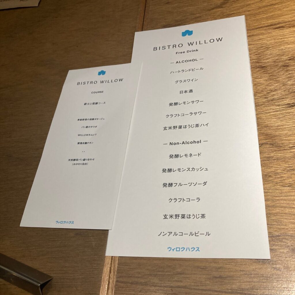 コースのお品書きと飲み放題メニューが記載された紙が写っています。