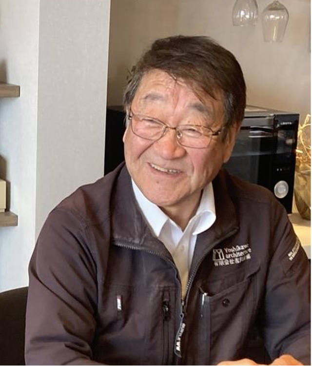 メガネをかけた男性が笑顔を浮かべています。