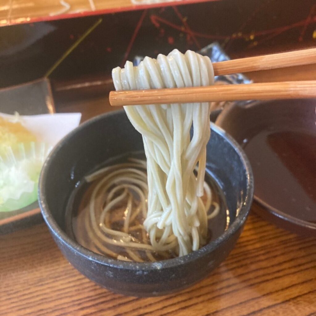 南蛮鴨だしにつけたへぎそばを箸で持ち上げています。