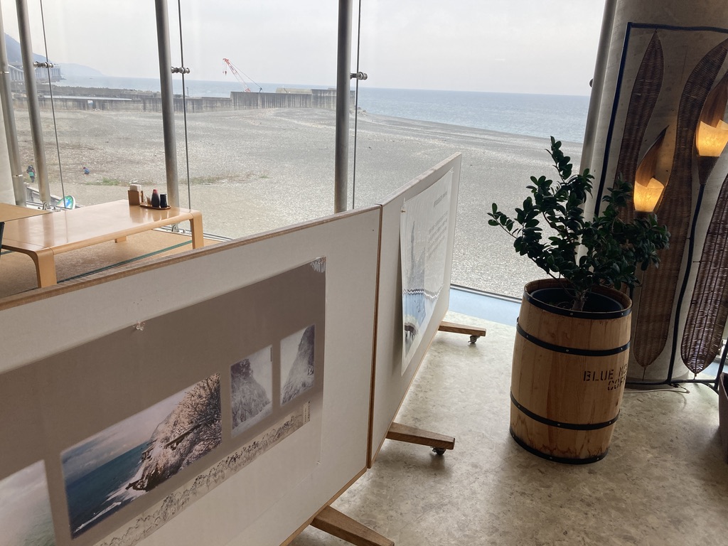 仕切りの奥に座敷、手前に観葉植物とオレンジのランプが写っています。