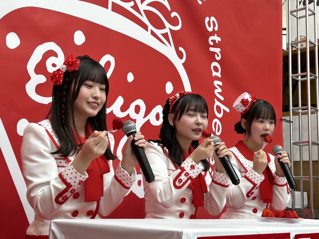 3人の女性が笑顔でいちごを試食しています