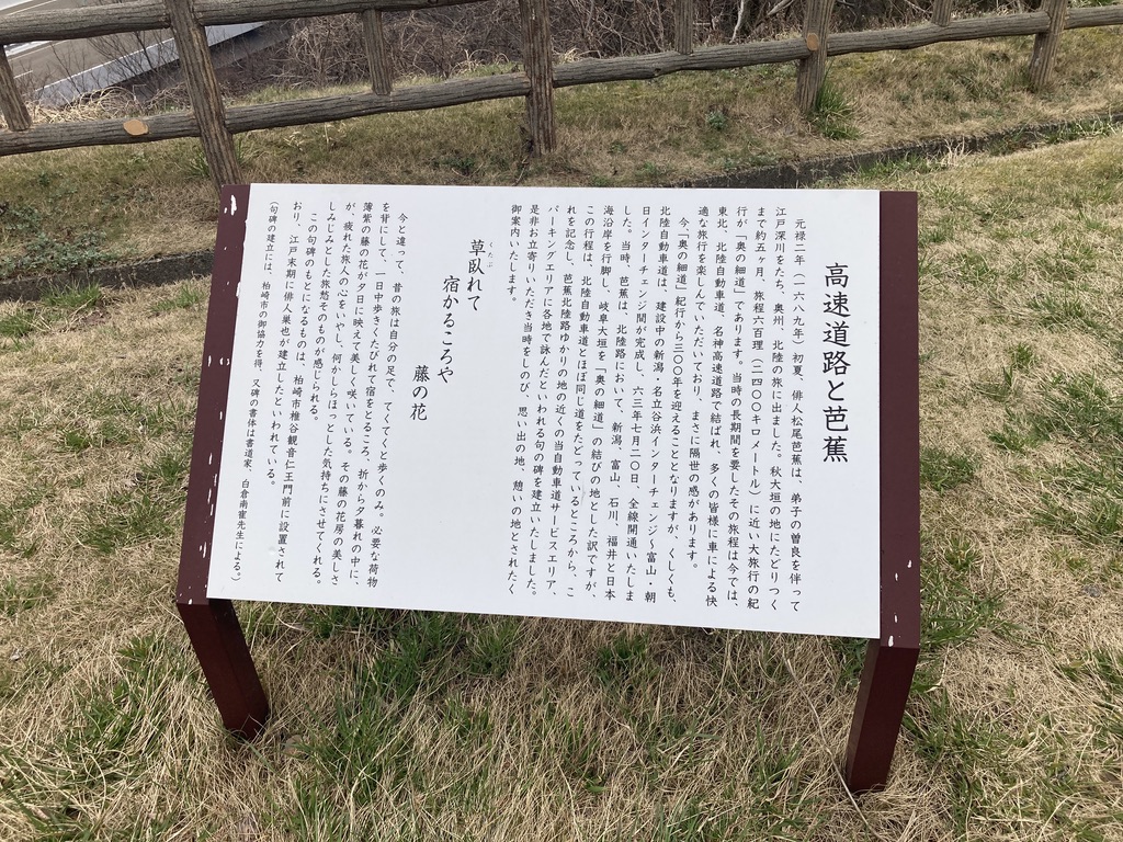 松尾芭蕉の「奥の細道」旅と北陸自動車道がほぼ同じ道であることから芭蕉の句碑を建てていることの説明書きです。
その句碑の「草臥せて 宿かるころや 藤の花」は芭蕉が一日中歩き、疲れ切って宿を取る夕暮れどきに藤の花を見つけ、夕日に映える薄紫の美しさに癒されたことを詠んだものということが書かれています。