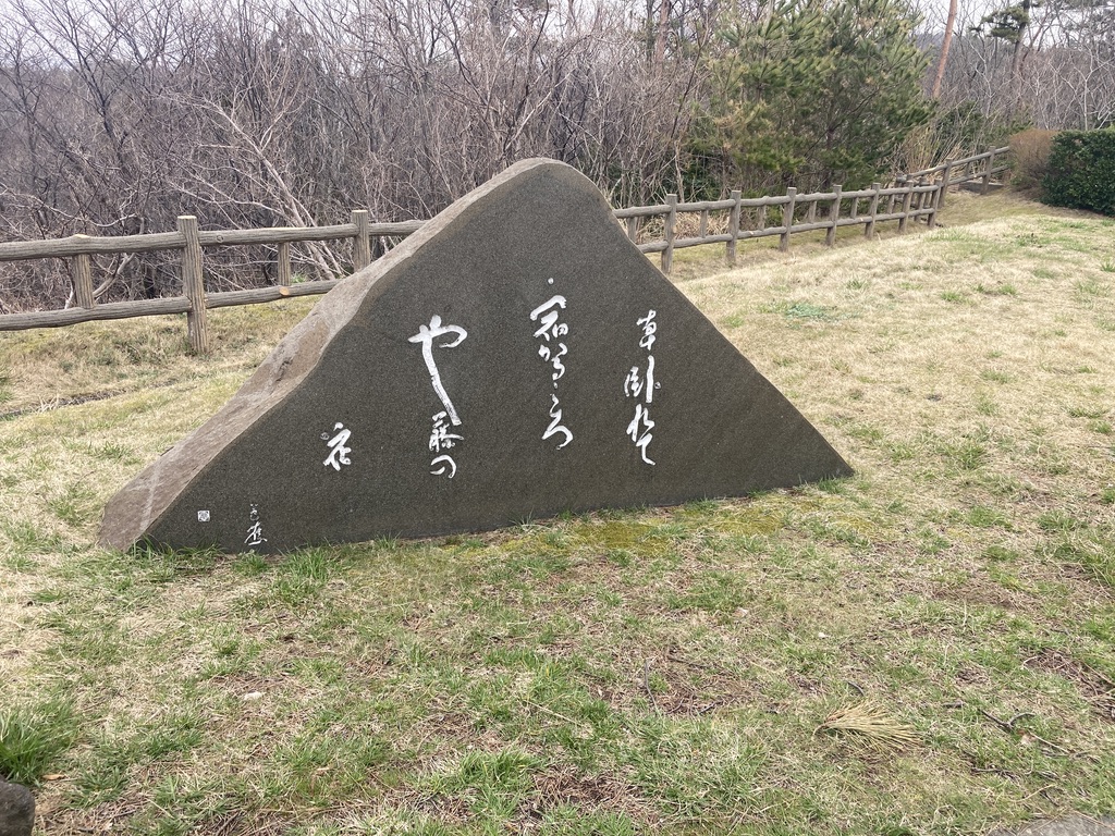 松尾芭蕉の「草臥せて 宿かるころや 藤の花」という句を刻んだ句碑が写っています。