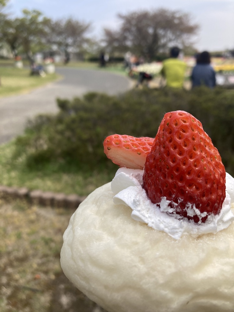 白いパンを土台にして、ホイップの上にいちごが立っています。いちごは半分にカットされ、交差する向きで刺さっています。