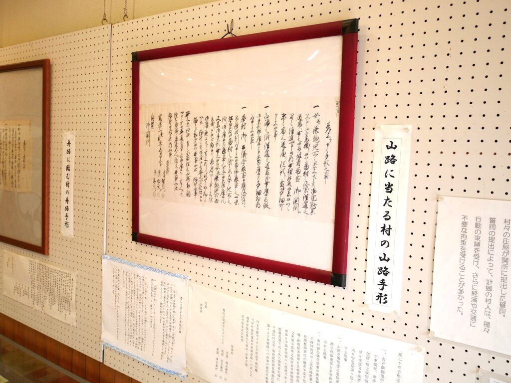 館内右側の壁に展示されている「山路に当たる村の山路手形」）
