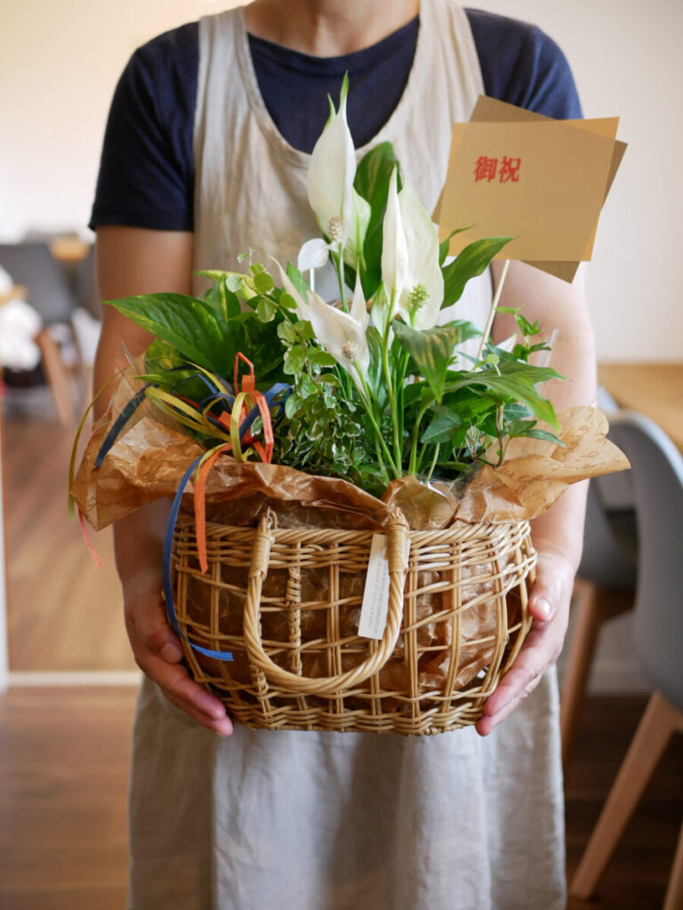 開店祝いのお花を持ったオーナー